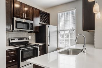 A kitchen with a white countertop and black appliances.